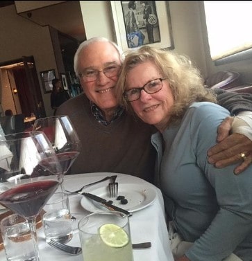 Picture of  Erin Coscarelli's parents posing for a photoshoot wearing red and grey color sweeter